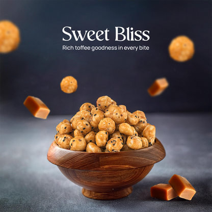 Bowl of toffee-coated makhana on wooden stand, caramel pieces in the air
